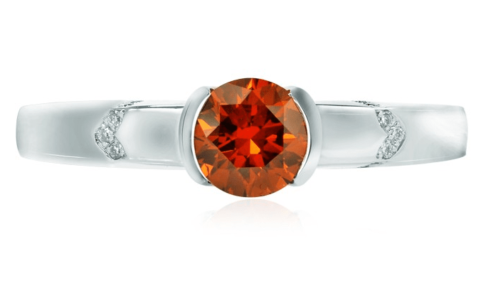 A bezel set 0.55 ct TW Fancy deep brownish orange round brilliant diamond ring with collection color white round brilliant accents